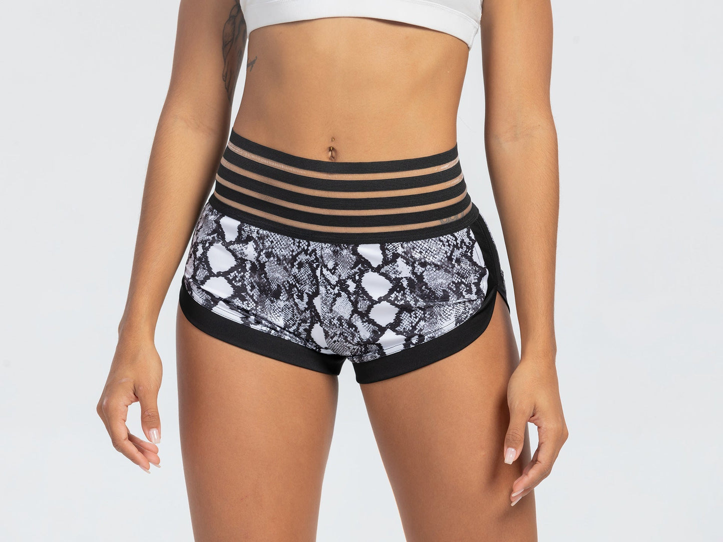 Black and white patterned shorts with a striped waistband on a plain background