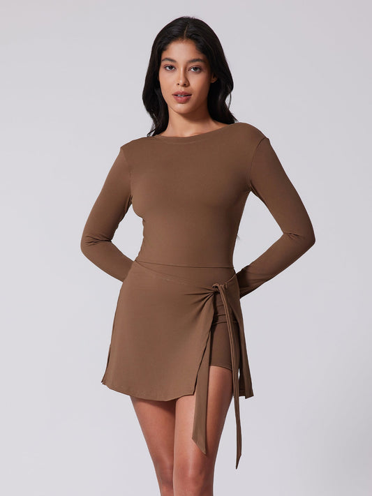 YOGA Woman wearing a brown dress with a tie detail on a plain background