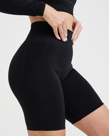 Black athletic shorts worn by a person on a light gray background