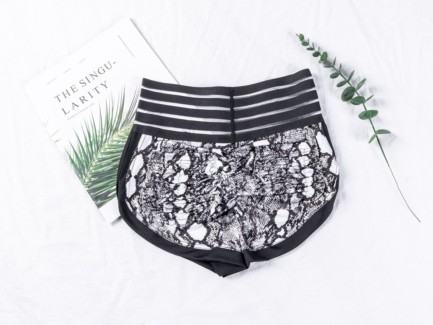Black lace shorts with striped waistband on a white background
