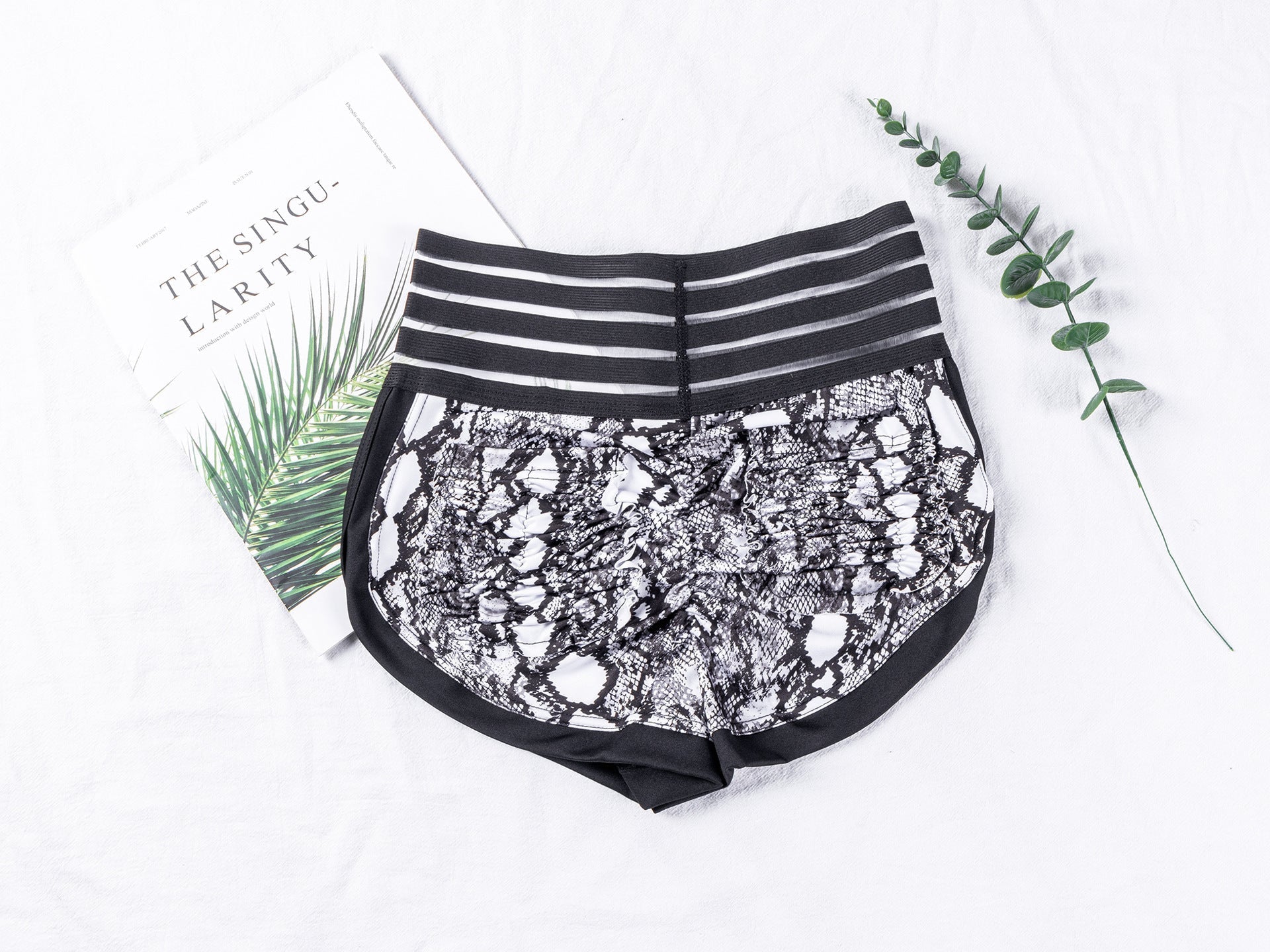 Black lace shorts with striped waistband on a white background