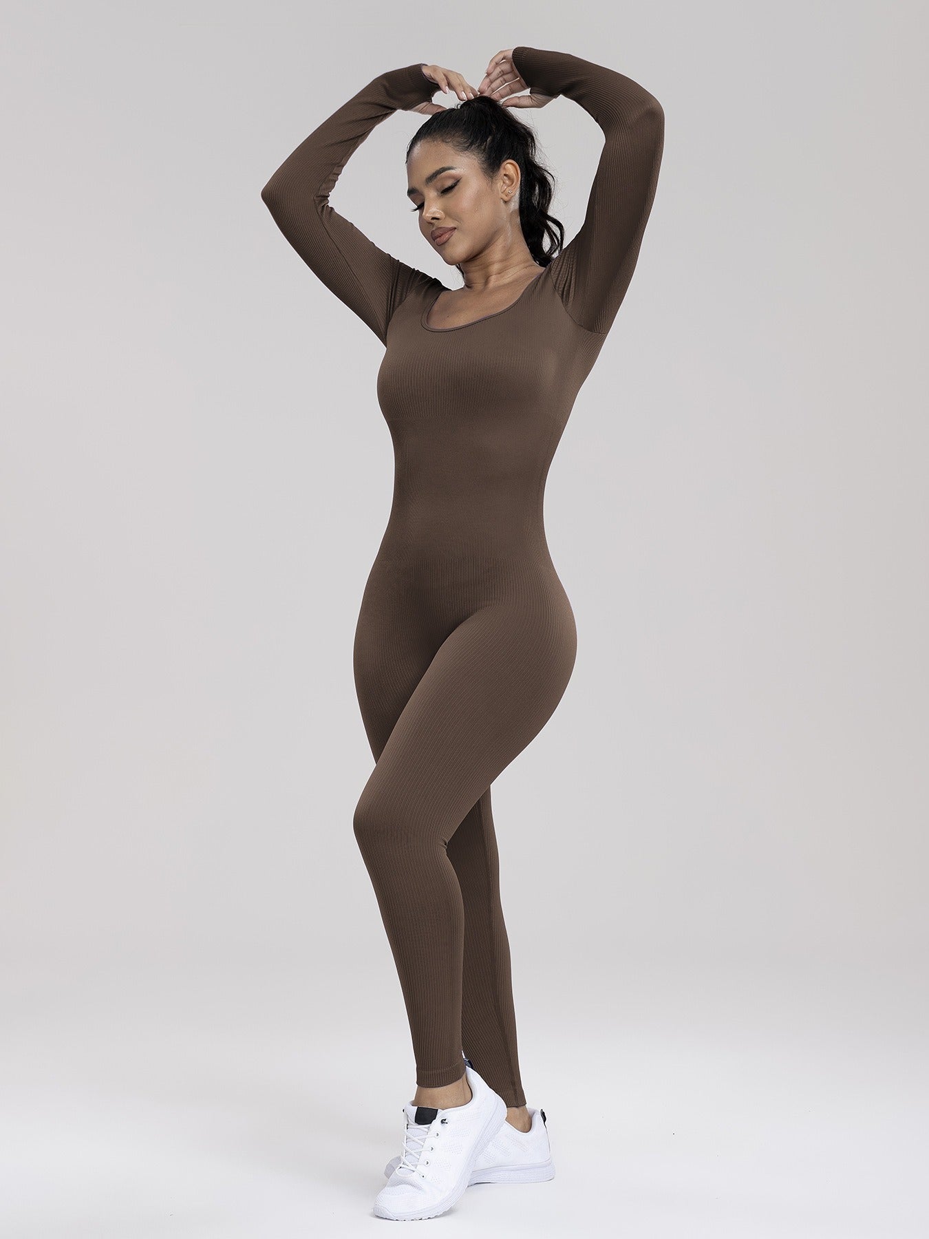 Person wearing a brown bodysuit on a white background