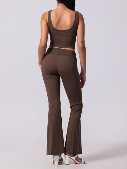 Person wearing a brown outfit with flared pants on a white background