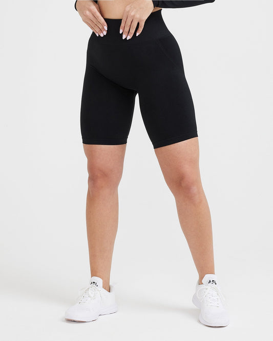 Person wearing black high-waisted shorts on a white background