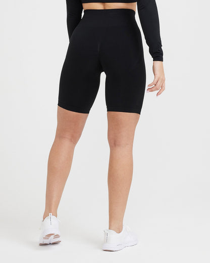 Person wearing black high-waisted bike shorts on a white background