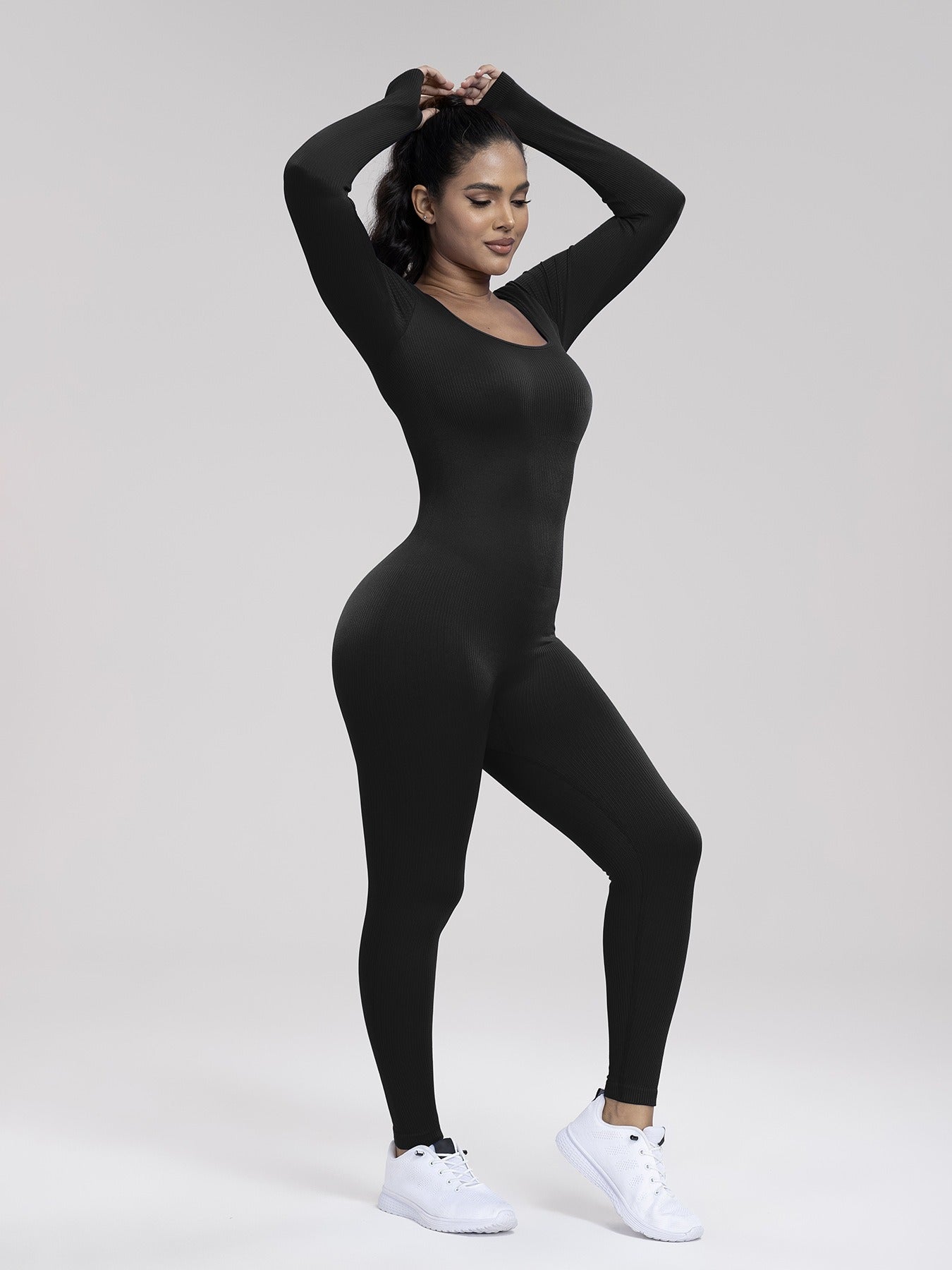 Person wearing a black bodysuit on a white background