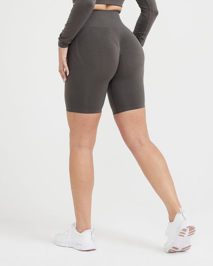 Person wearing gray high-waisted bike shorts on a white background