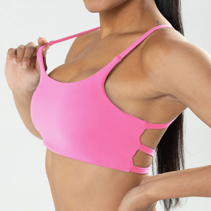 Pink bikini top worn by a person on a plain background