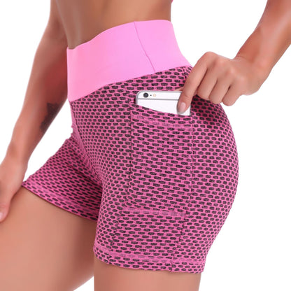 Pink patterned shorts with a pocket holding a phone on a white background