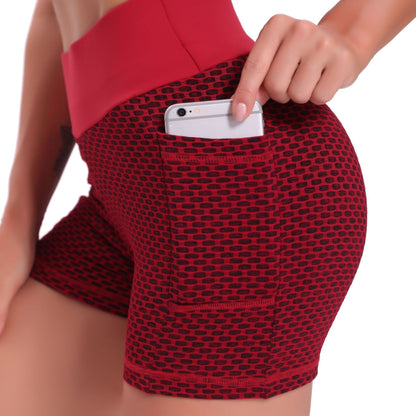 Red patterned shorts with a pocket being used to hold a phone.