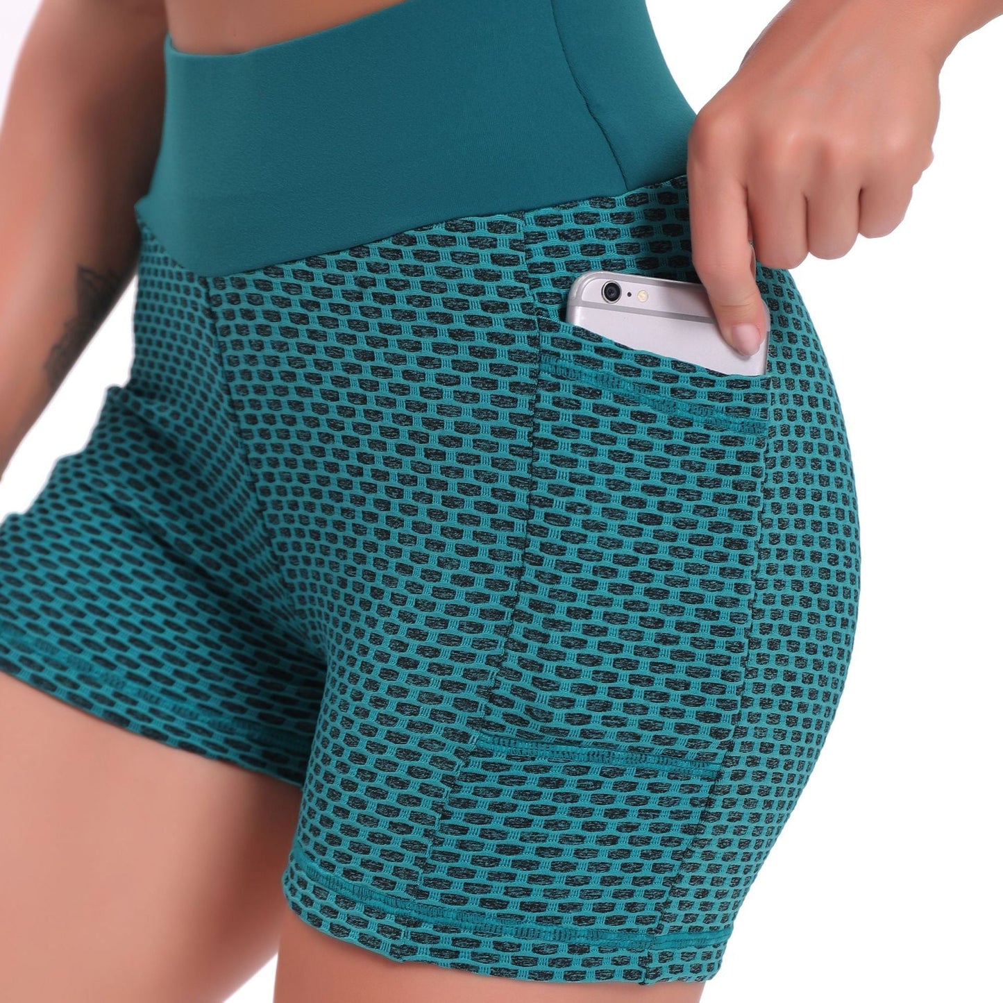 Teal patterned shorts with a pocket holding a phone on a white background