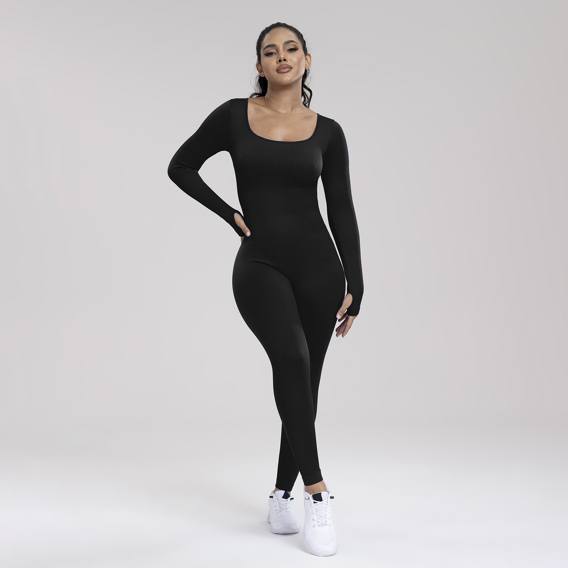 Woman wearing a black bodysuit on a white background