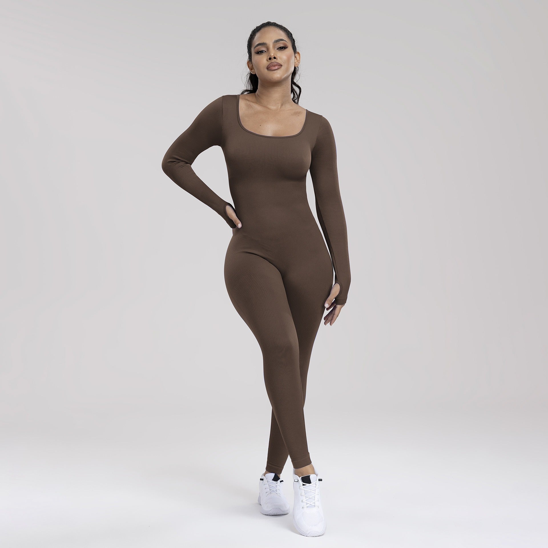Woman wearing a brown bodysuit on a white background