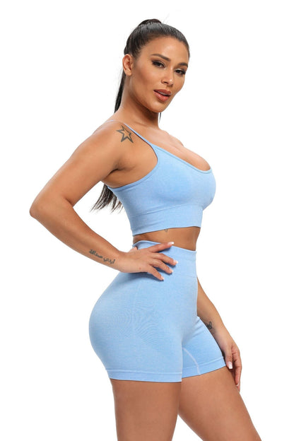 Woman wearing a light blue sports bra and shorts set on a white background