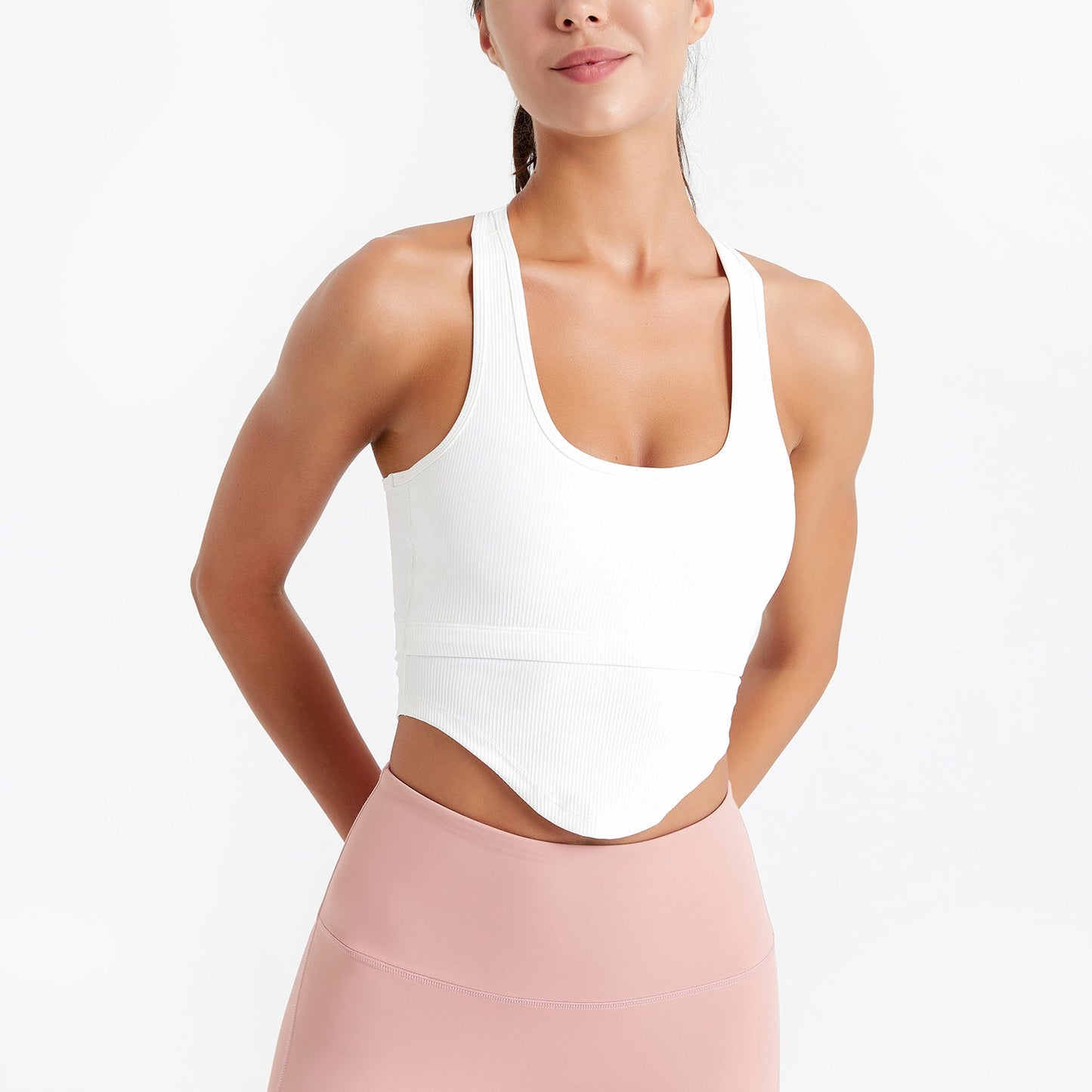 Woman wearing a white halter top and pink pants on a white background