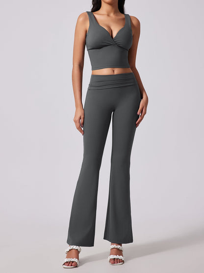 Woman wearing a gray sports bra and leggings set on a light gray background