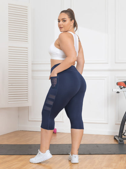 Woman wearing navy leggings with mesh panels in a home setting
