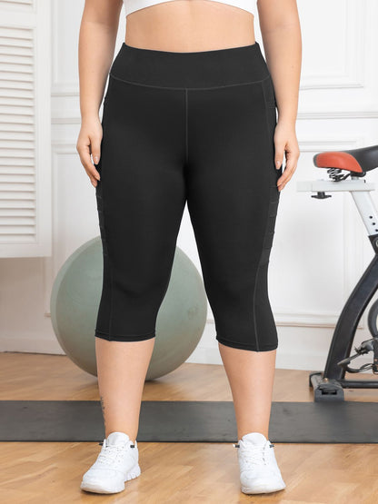 Person wearing black capri leggings in a gym setting